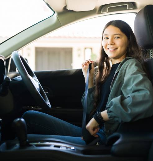 Young driver in car, learning to drive.